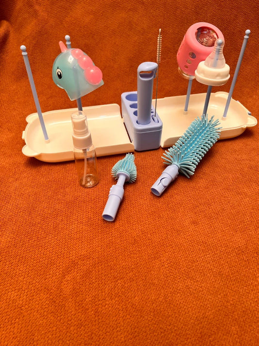 Baby bottle cleaning set with various brushes and holders on an orange surface