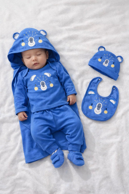 Baby in blue bear-themed outfit with matching hat and bib on a white background