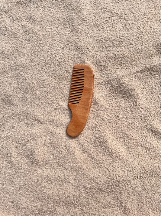 Wooden comb on a textured beige surface